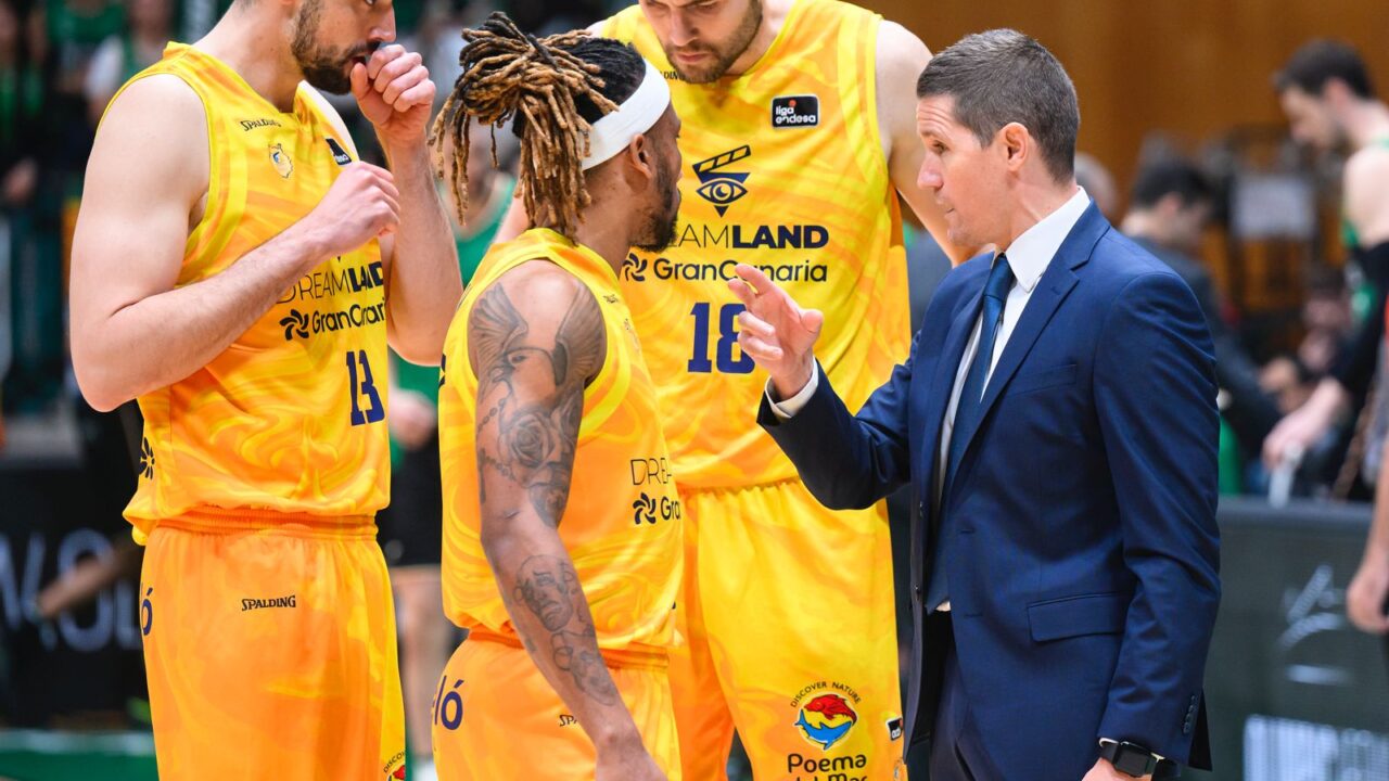Jugadores del Gran Canaria conversan con el entrenador durante un partido.