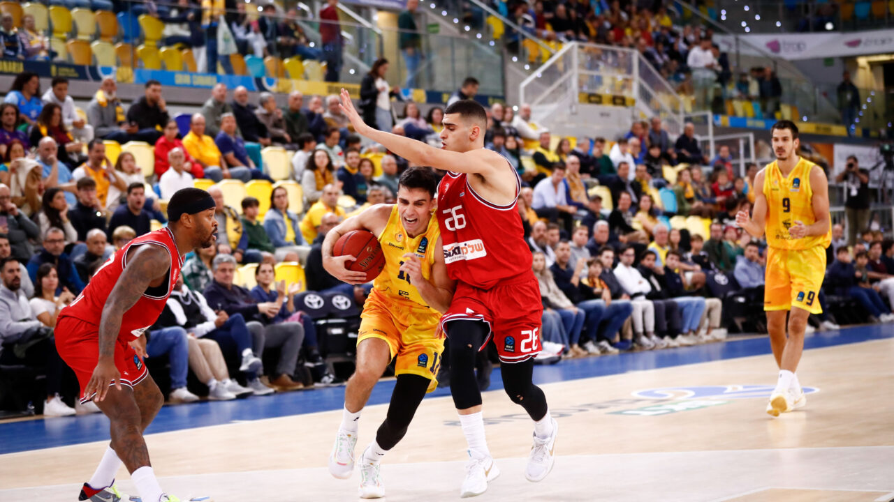 Jugadores en acción durante un partido de baloncesto en el Palacio de Deportes de Granada.