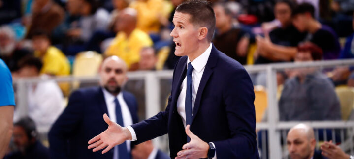 Entrenador gesticula enérgicamente durante un partido de baloncesto.