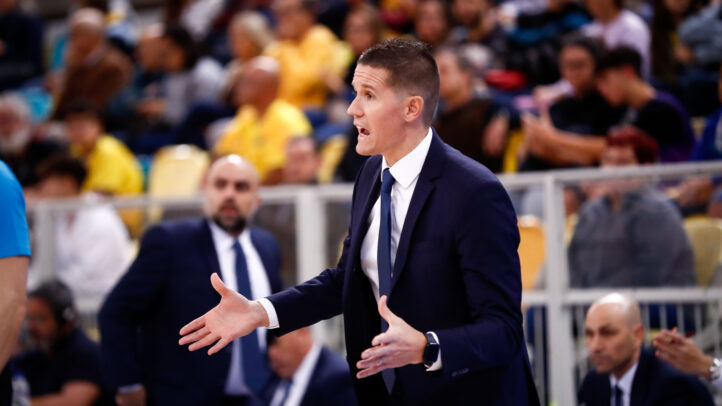 Entrenador gesticula enérgicamente durante un partido de baloncesto.