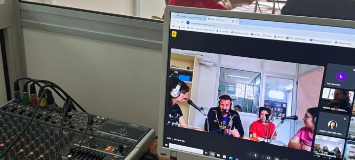 Estudio de grabación con personas hablando y una pantalla mostrando una videoconferencia.
