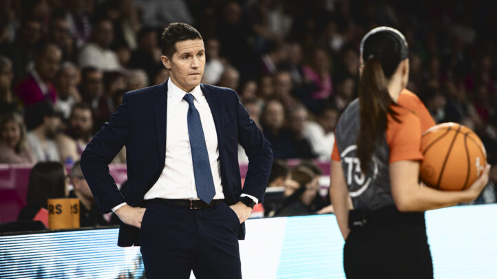 Jaka Lakovic observa un partido, con un árbitro sujetando un balón cerca de él.