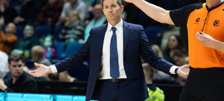 Entrenador mostrando gestos de frustración mientras un árbitro le señala.