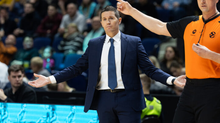 Entrenador mostrando gestos de frustración mientras un árbitro le señala.