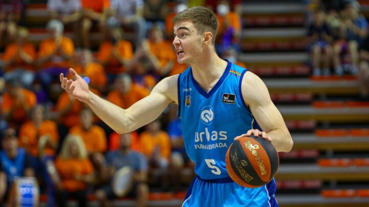 Jugador de baloncesto gesticulando y sosteniendo un balón en un partido.