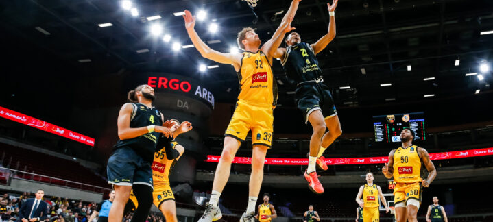 Jugadores en acción durante un partido de baloncesto en el Ergo Arena.