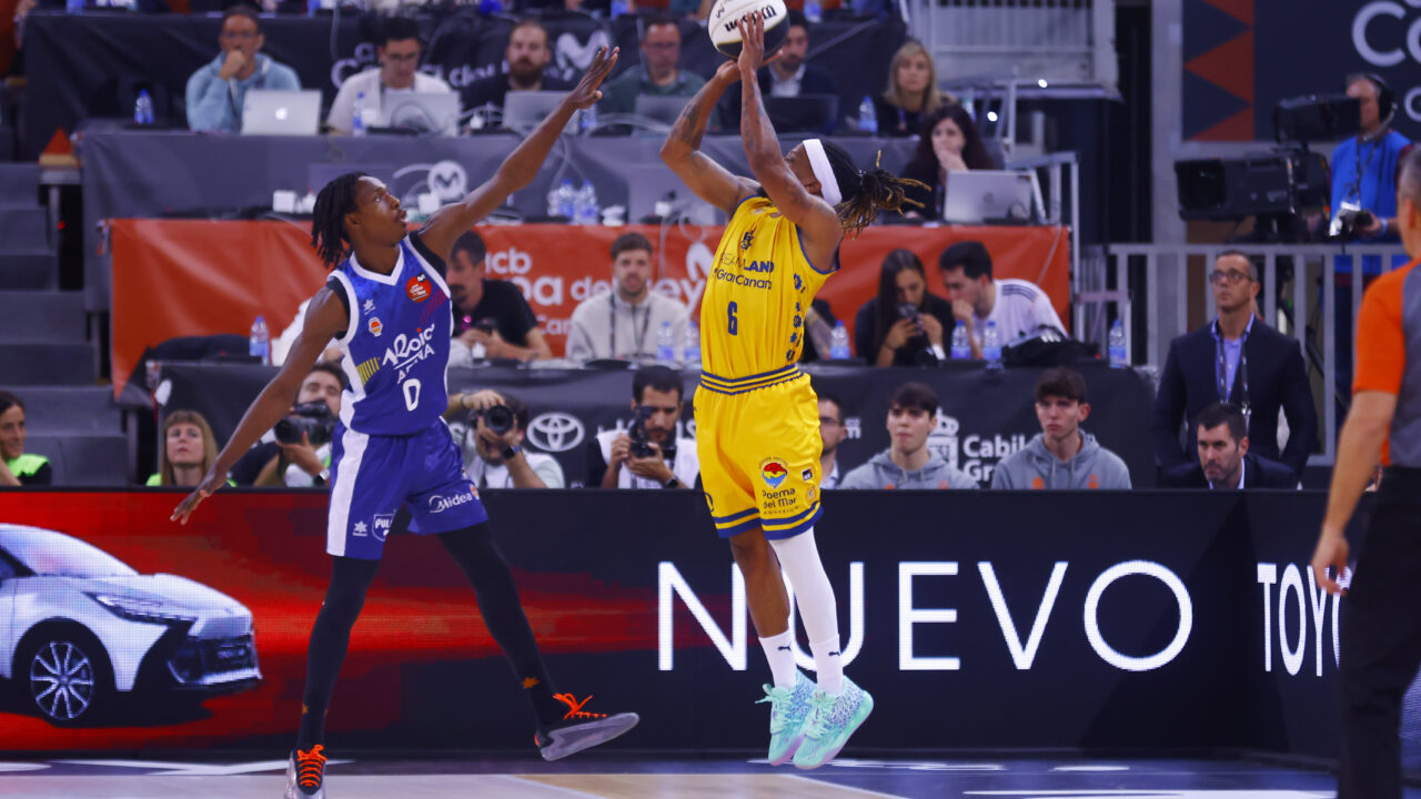Jugador del Dreamland Gran Canaria lanzando a canasta mientras es defendido.