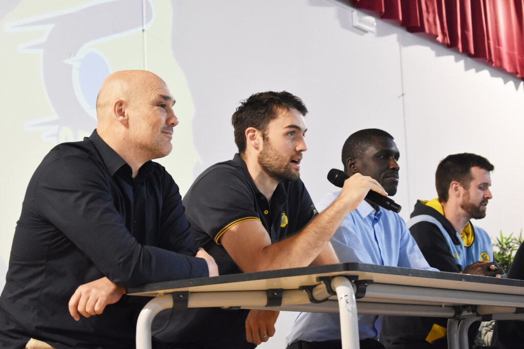 Cuatro miembros del Club Baloncesto Gran Canaria en una charla con micrófono.
