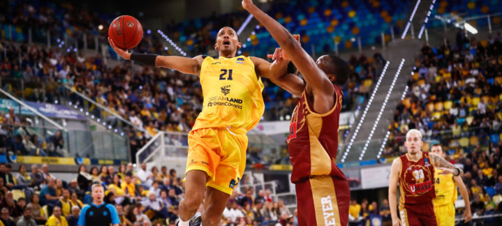 en diez claves","Jugador realizando un lanzamiento en un partido de baloncesto, con público animado.