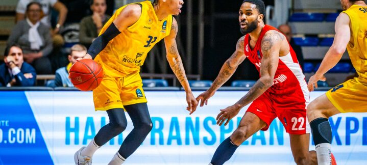 Jugador del CB Gran Canaria driblando el balón mientras es defendido por un adversario.