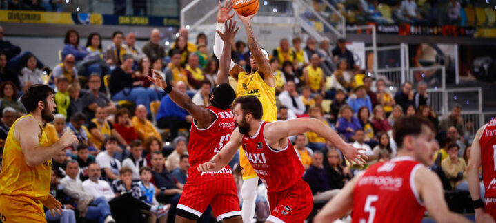 Caleb Homesley lanza a canasta durante un intenso partido de baloncesto.