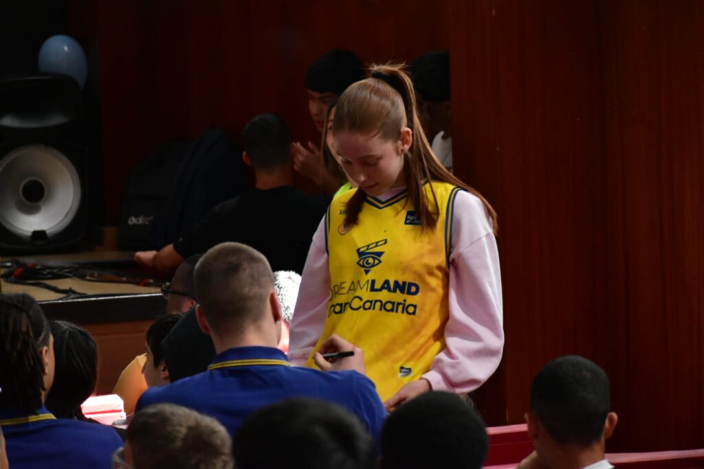 protagonista en las II Olimpiadas Inclusivas del IES Ana Luisa Benítez",Jugadora del CB Gran Canaria interactuando con un grupo de jóvenes durante un evento.