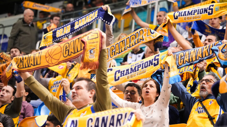 adquiere tu entrada para la final de la BKT EuroCup antes del lunes 7",Aficionados del Club Baloncesto Gran Canaria animan con bufandas en un evento deportivo.