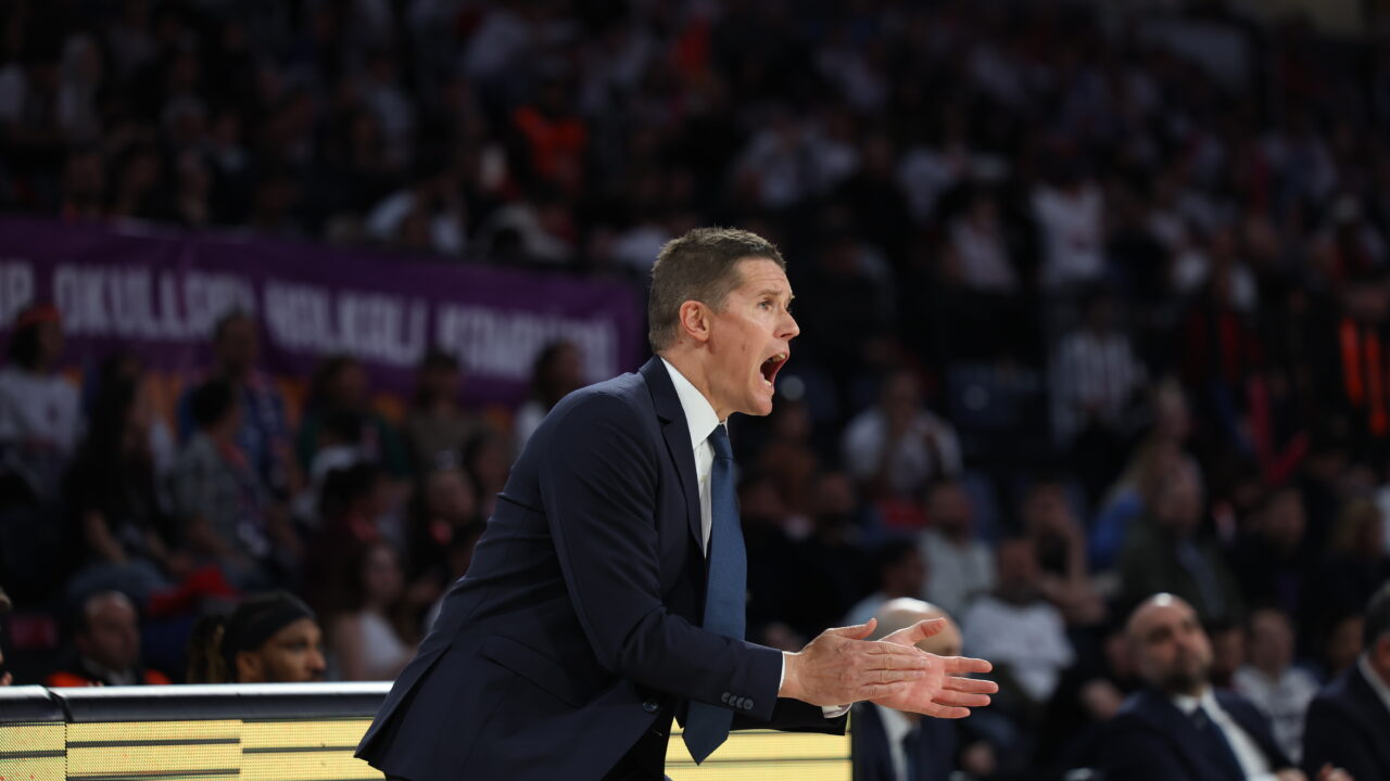 Entrenador en acción, dirigiendo al equipo durante un partido de baloncesto.