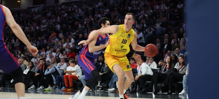 Jugador del Club Baloncesto Gran Canaria driblando el balón en un partido intenso.