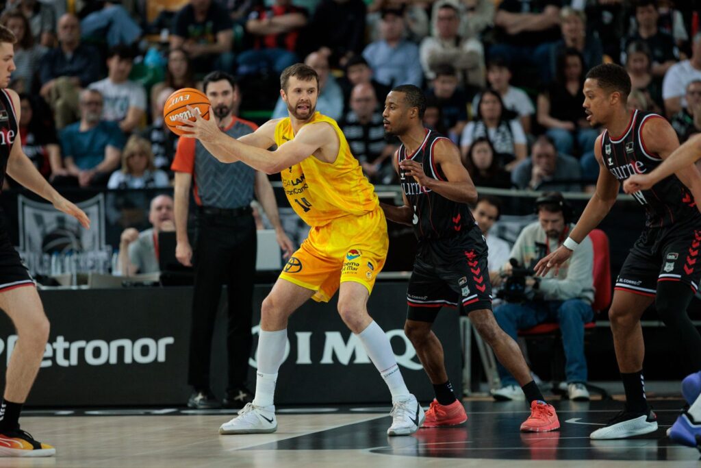 Jugador del Club Baloncesto Gran Canaria con balón, defendido por rivales en el partido.