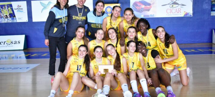 al Campeonato de España",Jugadoras y entrenadores del equipo júnior posan en la cancha con un trofeo.