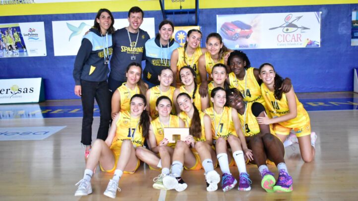 al Campeonato de España",Jugadoras y entrenadores del equipo júnior posan en la cancha con un trofeo.
