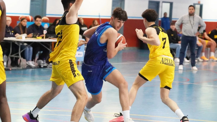 Jugadores de baloncesto en acción durante un partido, con uno sosteniendo el balón.