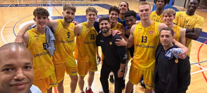 Jugadores del Gran Canaria posan sonrientes tras un partido en la cancha de baloncesto.