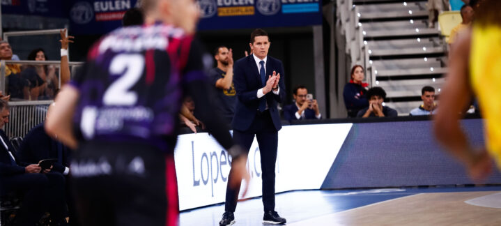 Jaka Lakovic aplaudiendo desde la banda durante un partido de baloncesto.