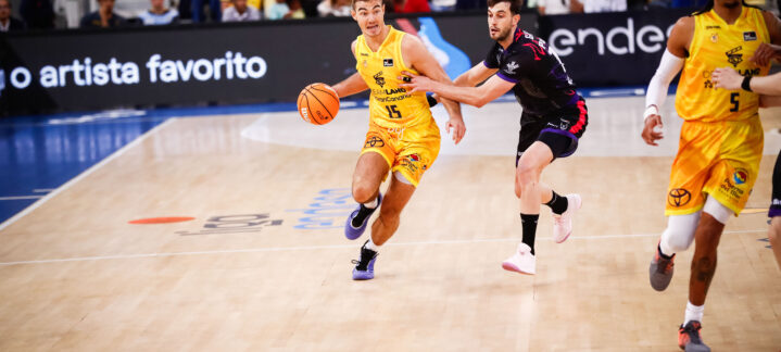 Jugador del Gran Canaria driblando el balón mientras es defendido por un rival.