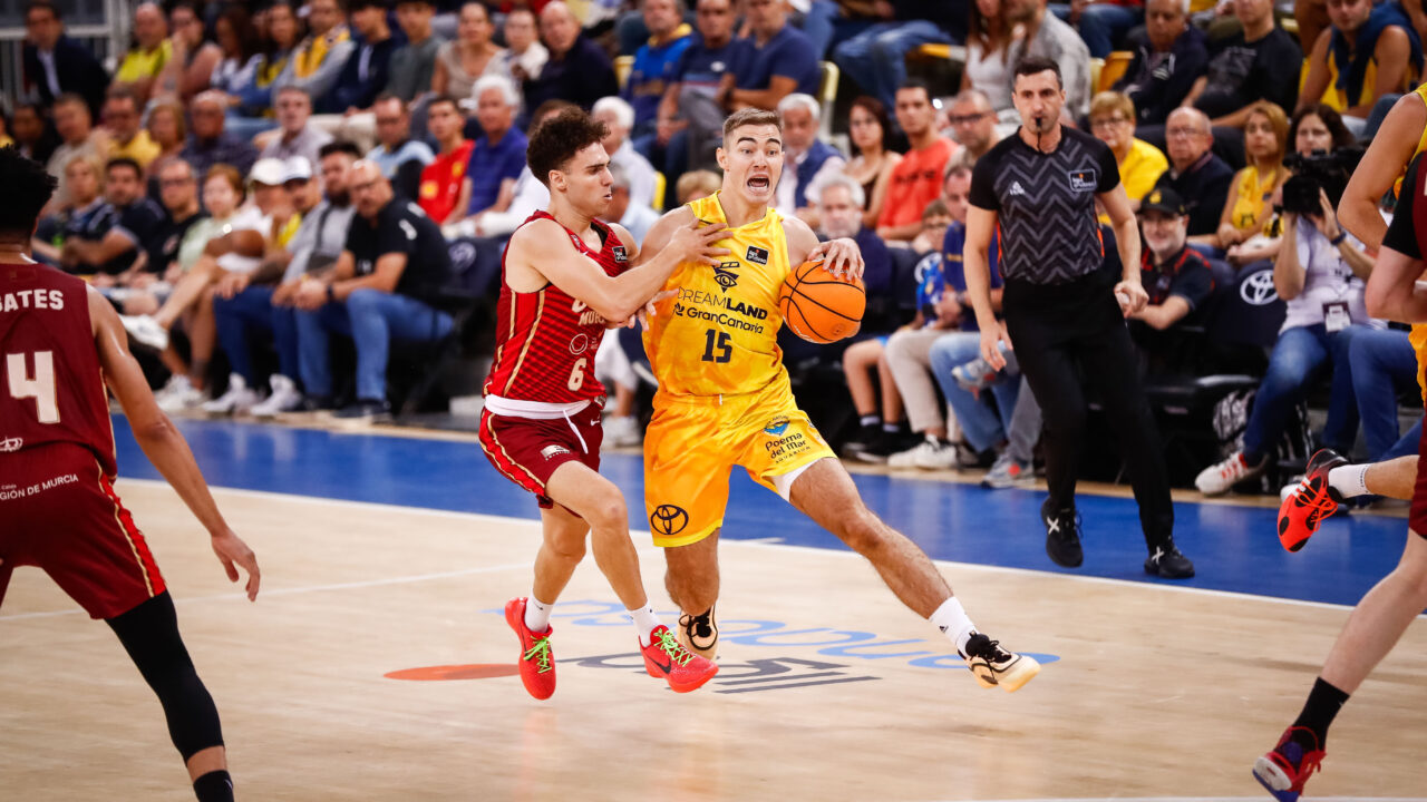 Jugadores del Dreamland Gran Canaria y otro equipo en acción durante un partido de baloncesto.