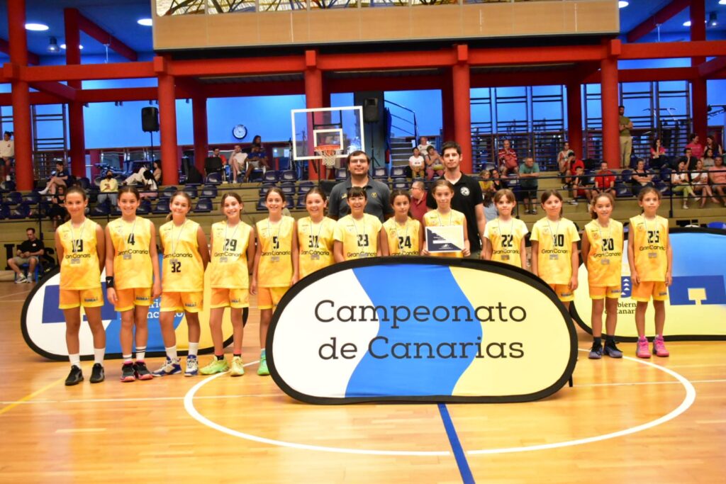 Equipo de preminibasket con medallas en el Campeonato de Canarias, posando en la cancha.