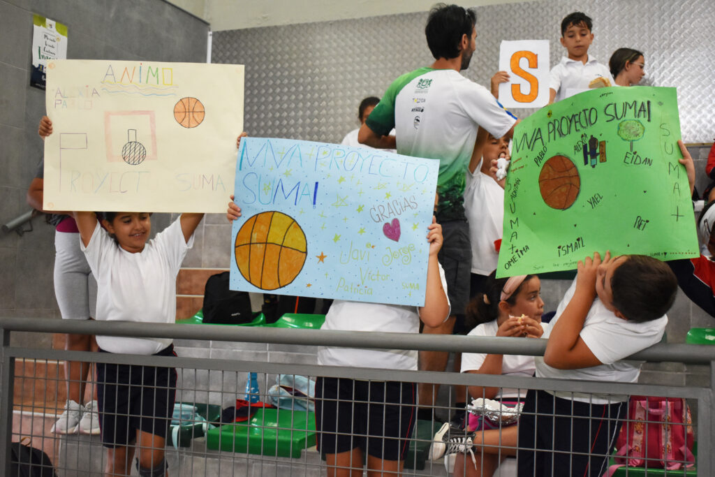  estrellas en la visita del CEIP María Muñoz Mayor de Agüimes",Niños sosteniendo carteles de apoyo al Proyecto Suma durante un evento del club.