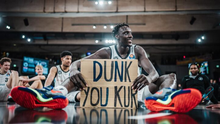 potencia interior para el Dreamland Gran Canaria","Jugadores sonrientes en un evento, con Kur Kuath sosteniendo un cartel que dice ""DUNK YOU KUR"".