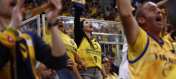 2%",Aficionados del CB Gran Canaria animando con camisetas amarillas en un partido.