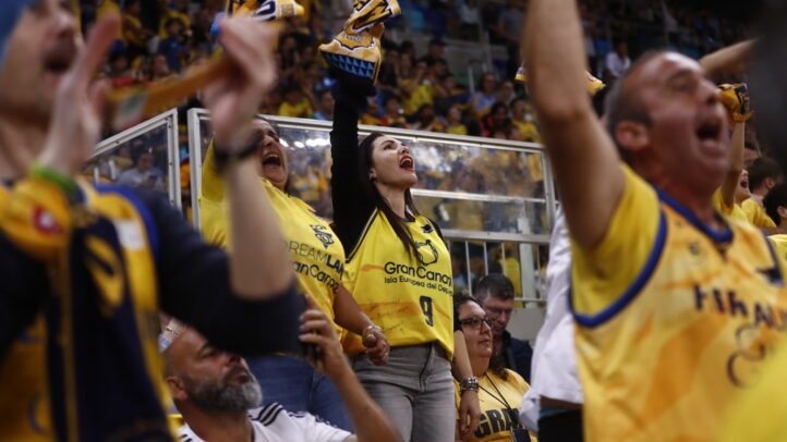 2%",Aficionados del CB Gran Canaria animando con camisetas amarillas en un partido.