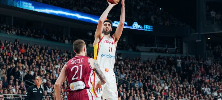 Baloncestista levantando el brazo para lanzar una pelota durante un partido.