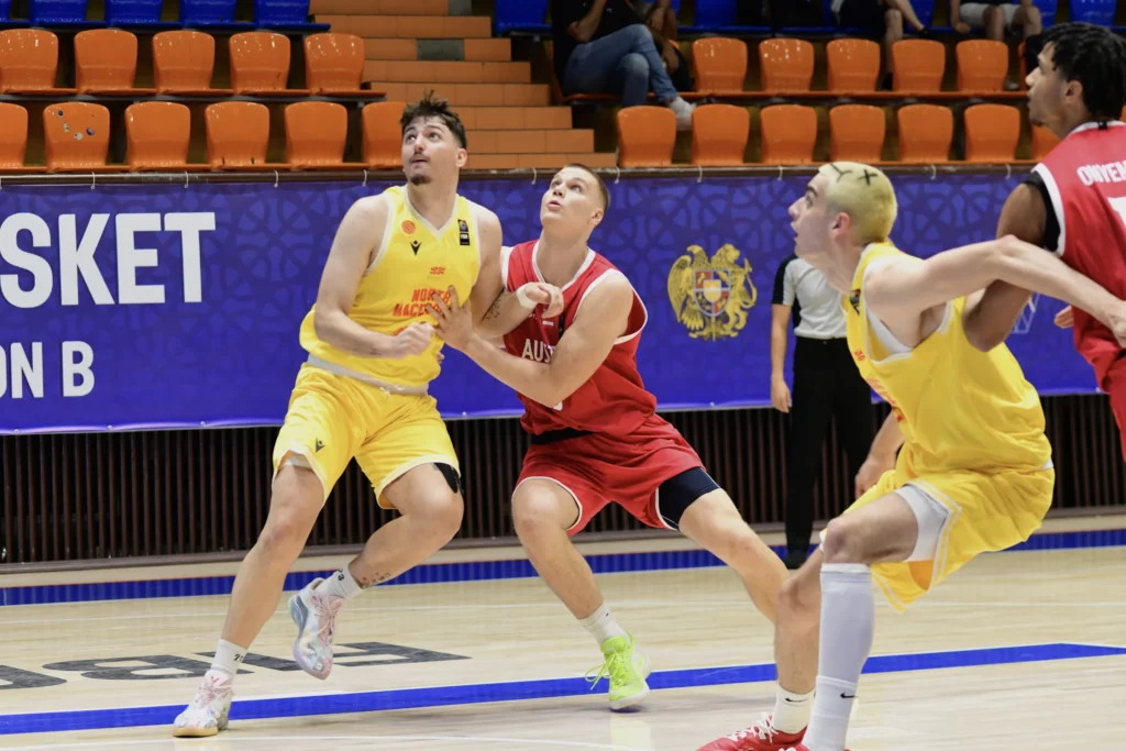 Jugadores de baloncesto compiten durante un partido internacional en la cancha.