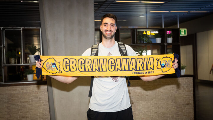 a su llegada: ""Lo que se me pida, lo haré""","Jugador sostiene una bufanda del CB Gran Canaria, sonriendo en un lugar de recepción.
