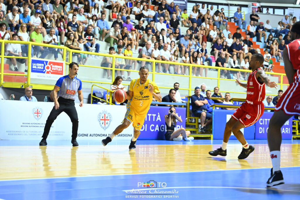 Jugador del Dreamland Gran Canaria driblando el balón en un partido. Público animado al fondo.