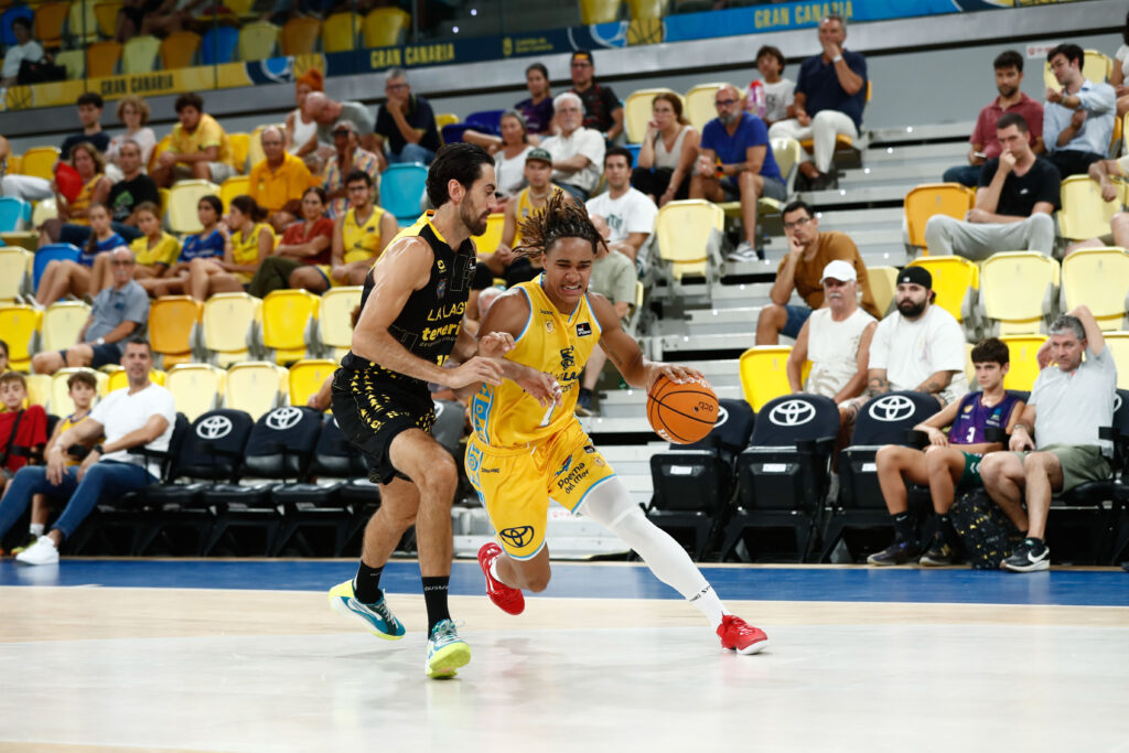 Jugador del Gran Canaria avanza con el balón mientras es defendido por un rival.