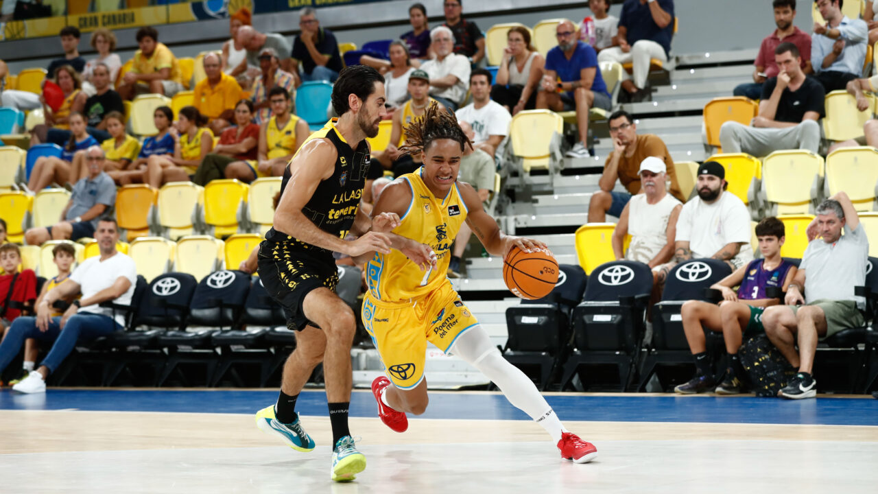 Jugador del Gran Canaria avanza con el balón mientras es defendido por un rival.