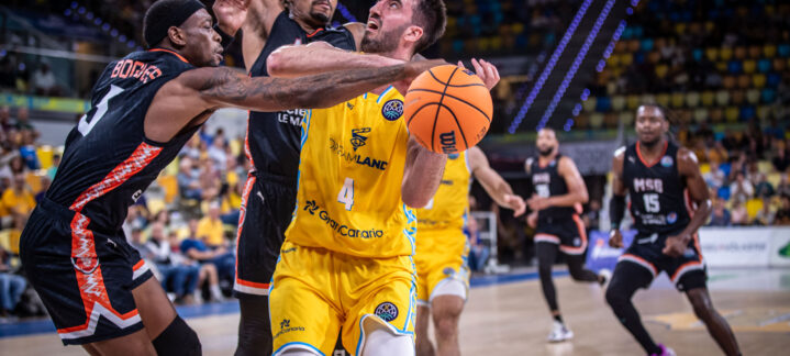 Jugador del Dreamland Gran Canaria intenta anotar mientras es defendido por rivales.