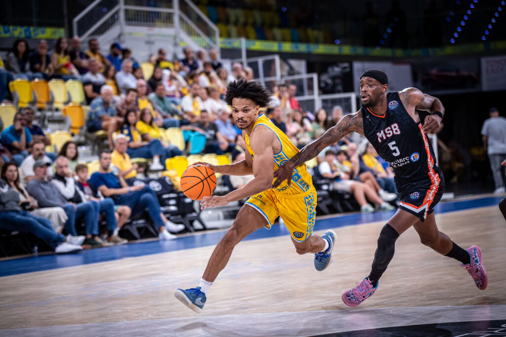 Jugador del Dreamland Gran Canaria conduce el balón mientras es defendido por un rival.