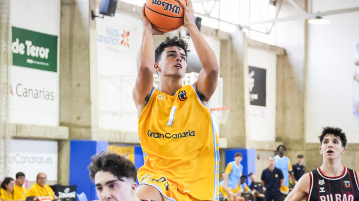Joven jugador de baloncesto lanza a canasta durante un partido en La Vega de San José.