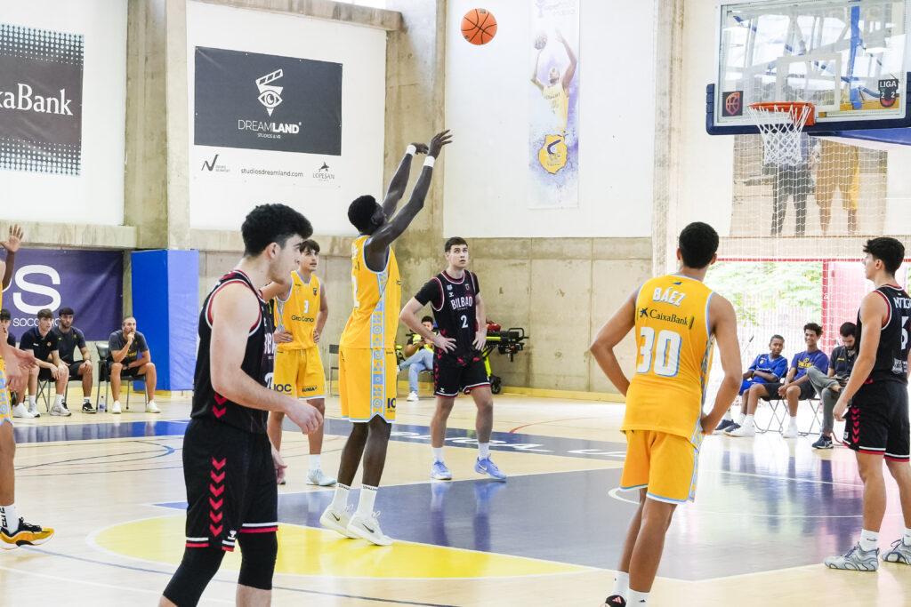Jugador lanzando un balón de baloncesto en un partido del U22 en La Vega de San José.