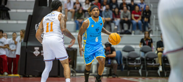 Jugador del Dreamland Gran Canaria driblando el balón en un partido de baloncesto.
