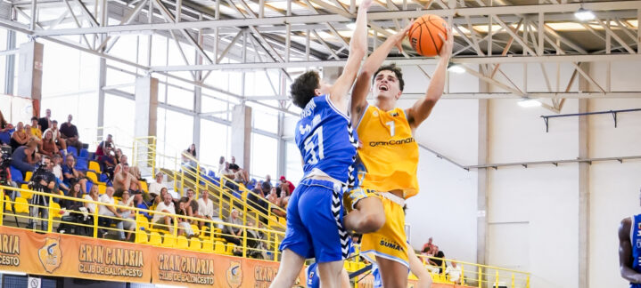 Jugador del Gran Canaria U22 salta para hacer una canasta mientras es defendido.